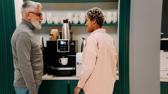 ein altes ehepaar vor der kaffeemaschine