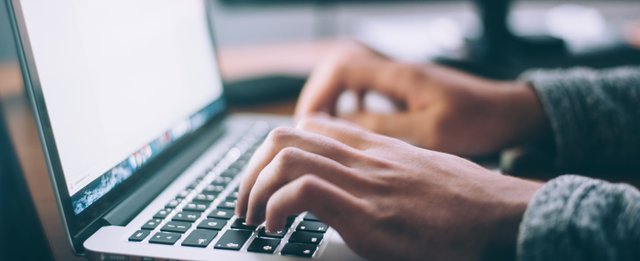 hände texten auf laptoptastatur