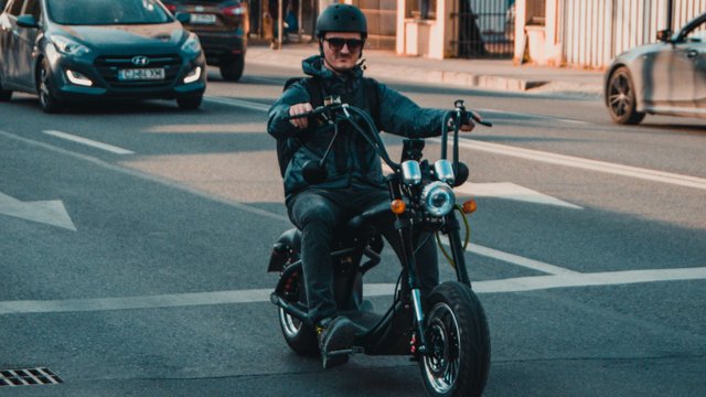 mann fährt roller auf der straße