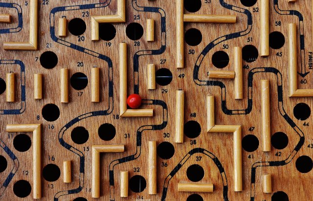 Labyrinth aus Holz mit roter Kugel