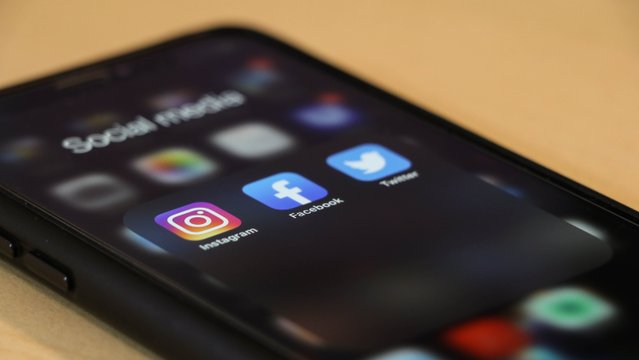Smartphone, an, mit Social-App-Ordner geöffnet