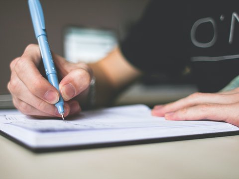 Mann schreibt mit Kugelschreiber