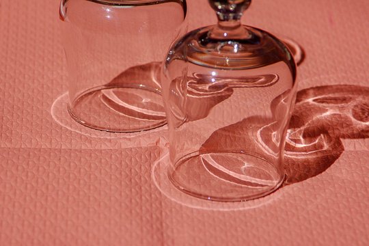Umgedrehte Weingläser auf rosa Tischdecke