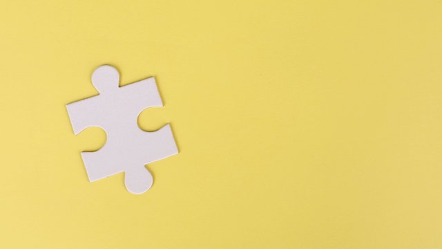 ein einzelnes Puzzlestück auf gelbem untergrund