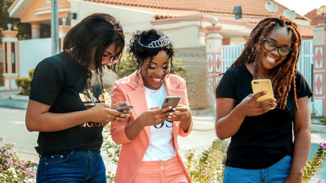 gruppe an mädels an ihrem smartphone