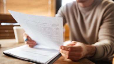 mann liest etwas von einem papier ab