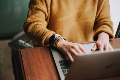 Frauenhände tippen auf Tastatur