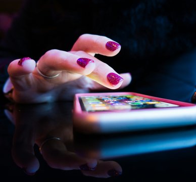 Handy wird von Frau mit lackierten Fingernägeln bedient