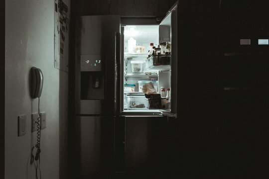 Offener Kühlschrank in der Dunkelheit