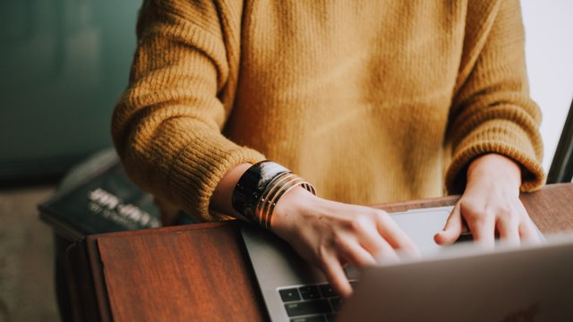 Frauenhände tippen auf Tastatur