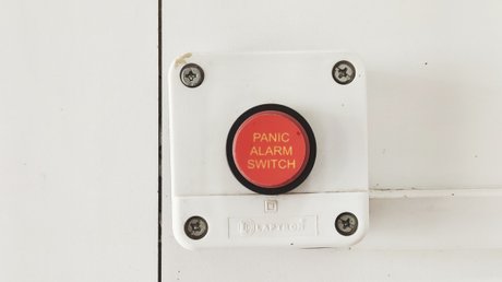 alarmknopf vor weißer wand 