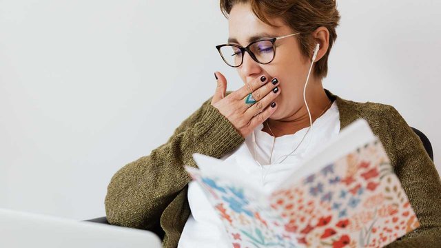 gähnende frau beim lesen