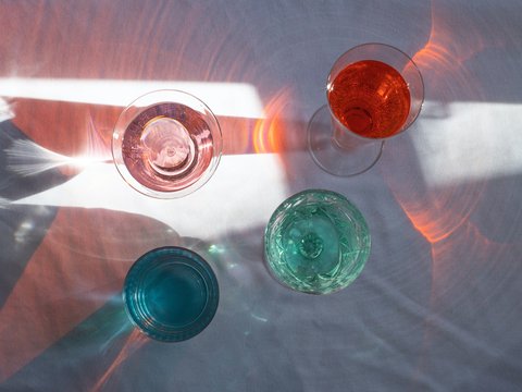 gläser mit verschiedenfarbigen flüssigkeiten leuchten in der sonne