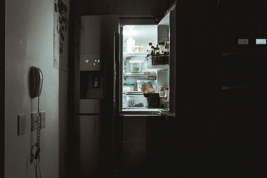 Offener Kühlschrank in der Dunkelheit